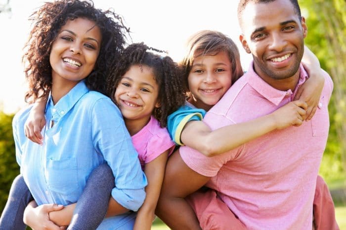 Group of family members smiling, displaying healthy teeth.