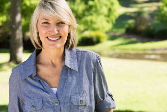 Smiling female practicing gum disease prevention.