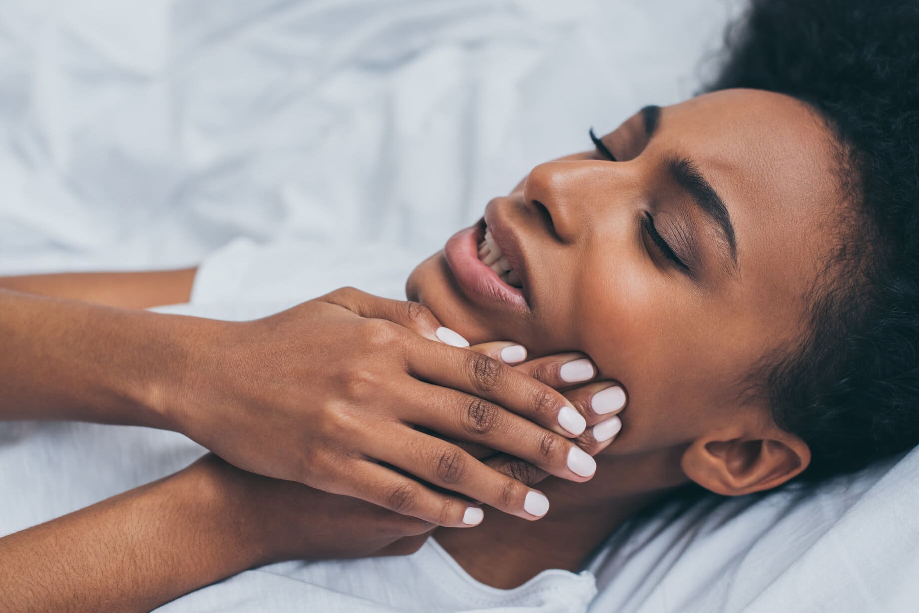 An African American woman experiencing tooth pain at Sudbury Dental Arts.