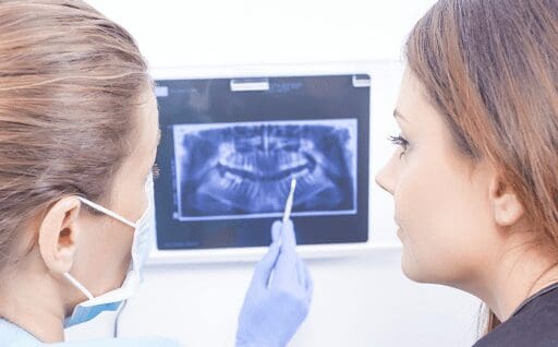 Dentist explaining the choice between extraction or root canal treatment to a patient at Sudbury Dental Arts.