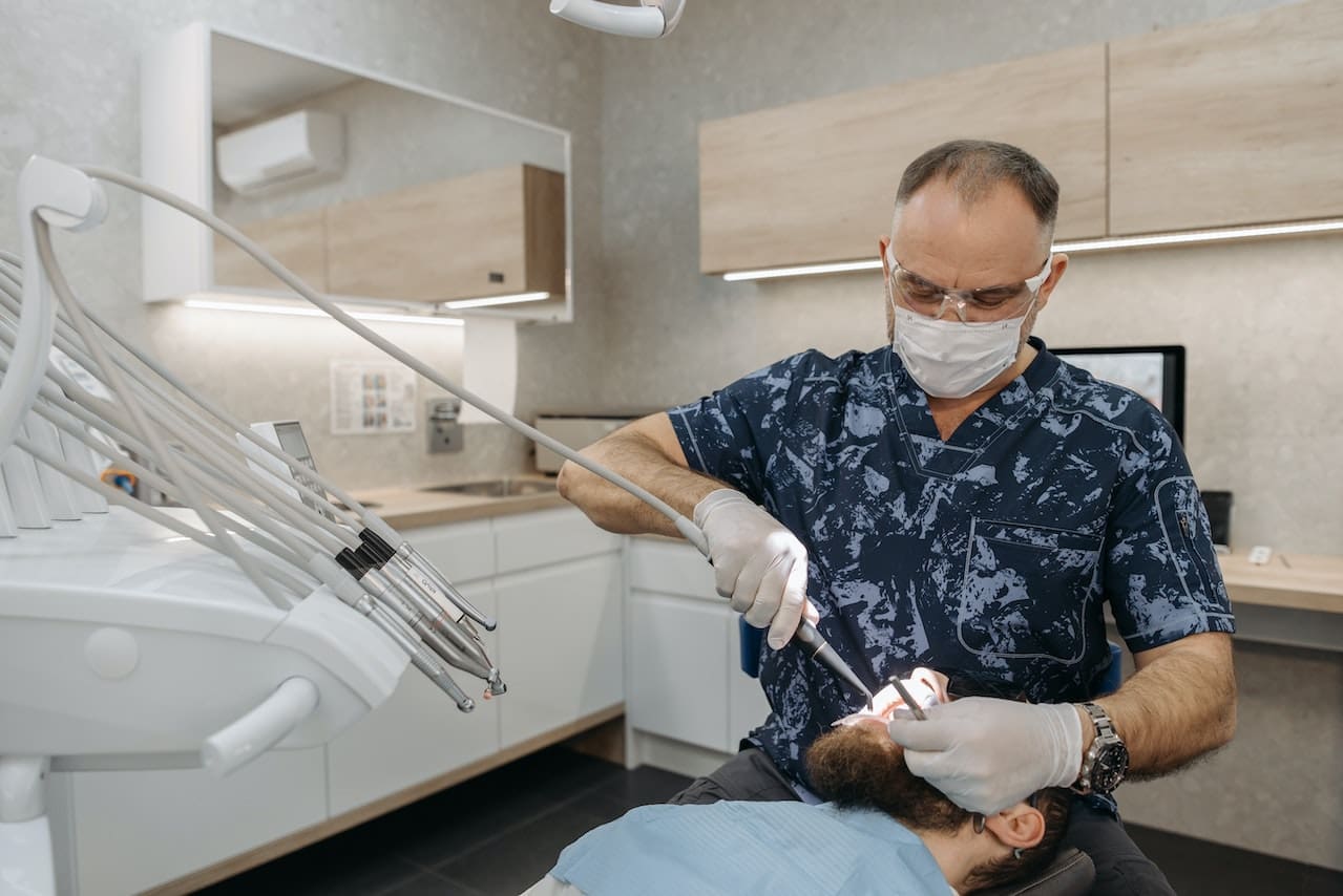 A dentist at Sudbury Dental performing a thorough cleaning of a customer's mouth.