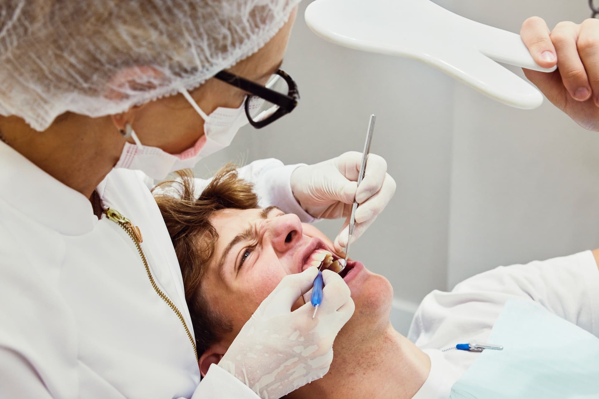 A dentist examining a patient's jaw for TMJ treatments.